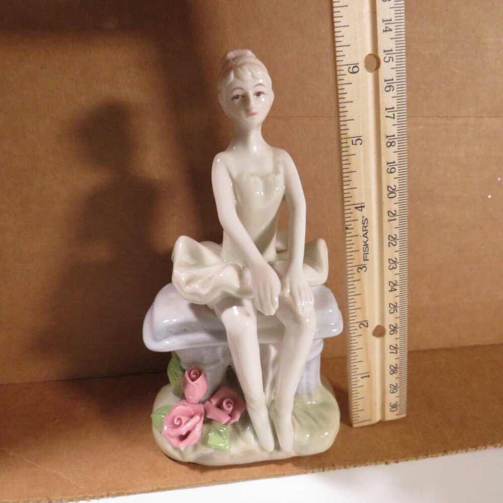Ceramic Ballerina Figure sitting on bench with Roses